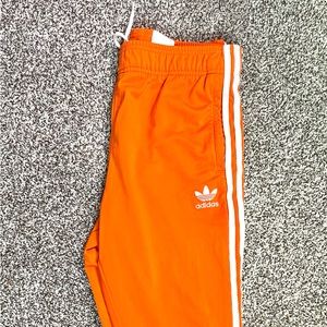 Orange and white adidas joggers.